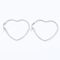 Detail view of a pair of silver heart-shaped stainless steel hoop earrings on white background - Heart (Steel Color)