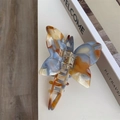 Detail of marble pattern acetate butterfly hair claw with Sunshine Handmade gold lettering - Butterfly Claw / Blue Brown Marble