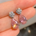 Elegantes pendientes de gota con gema rosa en forma de pera y engaste floral plateado de cerca - Rosa