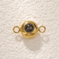 Macro shot of a golden stainless steel connector charm with circular dark projection stone - Gold Double Hole