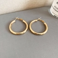 Detailed close-up of polished gold hoop earrings on a textured lifestyle background - Gold Smooth Polished (4cm)