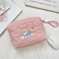 Detailed close-up of pink quilted makeup bag with puppy embroidery and zipper pull - Basket Puppy