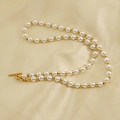 Elegant pearl necklace with alternating gold beads and a toggle clasp on silk fabric - White