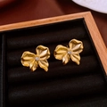 Dettaglio di orecchini a lobo a fiore dorati con zircone in una scatola portagioie in legno - Forma di Fiore con Fiocco / Oro