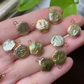 Hand holding natural baroque pearl pendant with golden bezel and iridescent luster - No.15 Width 12-13mm