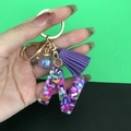 Detail of resin letter N keychain with purple tassel and colorful stone filling - Letter N