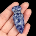 Blue and white sodalite stone dagger sculpture held by hand against a black background - Blue Sodalite