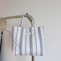 Vue détaillée du sac cabas matelassé à fleurs avec rayures bleues et motifs cerises - Rouge avec Petites Fleurs à Rayures