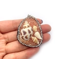 Ciondolo in resina di pietra arancione con conchiglia e strass tenuto in mano - Arancione
