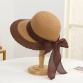 Detailed shot of two-tone woven sun hat featuring a large brim and stylish brown bow ribbon - Straw Peak Khaki