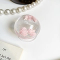 Transparent round phone socket with pink resin cloud decor on white desk background - Pink