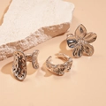 Anillos de flor plateados con texturas geométricas irregulares sobre fondo de piedra - Set de 3 piezas / Plateado