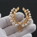 Golden wreath brooch with white pearls held in hand against a dark background - Wheat Ear Style (X0127)