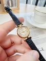 Close-up of elegant gold watch with Roman numerals and black leather strap on a desk - Black Leather Strap