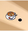 Detalle de un pin de esmalte vintage con taza de café, cuchara de plata y diseño de corazón - Taza de Café Latte Art