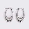 Macro detail of silver geometric U-shaped earrings with textured vertical stripe design - Steel