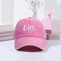Pink washed cotton baseball cap with white Gigi embroidery on a stylish display stand - One Size / Pink