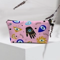 Detailed view of pink cosmetic bag with evil eye and hamsa hand motifs on a stand - Pink Base Mystic Eye