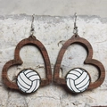 Dettaglio di orecchini a cuore in legno con motivo pallavolo su sfondo rustico - Pallavolo