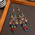 Dettaglio di orecchini boho con nappine e perline colorate su montatura in metallo dorato - Multicolore (3# Gancio per l'orecchio-Oro)