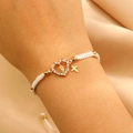 Detail of woven bracelet with heart pendant and Virgin Mary charm on satin background - KC Gold White Rope (G-449)