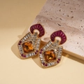 Gros plan détaillé de boucles d'oreilles baroques avec ambre et émail violet élégant - Or