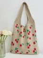 Close-up of beige knitted tote bag with cherry patterns and textured woven handles - Khaki