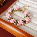 Dettaglio del bracciale con rosa in resina rosa, perle e foglie dorate con strass - Bracciale Rosa Rosa