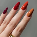 Unghie finte a mandorla corte in colori autunnali rosso scuro e arancio zucca - Modello con colla