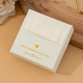 Elegant cream jewelry gift box with ribbon bow and gold foil text on wooden tray - Off-White Bow Tie