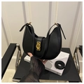Detail einer schwarzen halbmondförmigen Ledertasche mit goldener Schließe - Schwarz