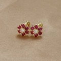 Detail of s925 silver flower earrings with red zircons and screw back on silk - Gold-Rose Red