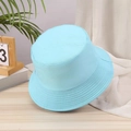 Detail shot of a light blue cotton twill bucket hat placed on a rustic wooden desk - One Size / Light Blue