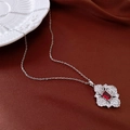 Detailed macro view of a red gemstone necklace with crystal floral accents on red silk - Necklace - Silver