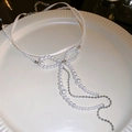 Detalle de gargantilla elegante de perlas con lazo y borlas largas en plato de cerámica - Collar de Lazo de Perlas Blancas