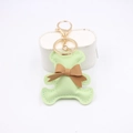 Dettaglio del portachiavi a forma di orso in pelle PU verde con fiocco marrone - Verde matcha