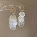 Vue macro de boucles d'oreilles cercles dorés avec pendentifs coquillages blancs et glands - Style Pendentif Coquille Cerceau en Métal / Or-Blanc