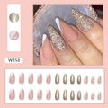 Close-up of elegant French tip press-on nails featuring golden glitter and nude pink finish - White Elf (W358)