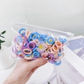Close-up of colorful elastic hair bands with daisy decor in a clear zipper bag - Light Medium Daisy Bag
