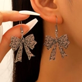 Close-up of leopard print bow earrings on model showing heart pattern detail - Purple Heart Leopard Bow (04 White K 6090)