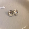 Dettaglio di orecchini a perno in metallo argento irregolari su un vassoio beige - Orecchini Geometrici / Argento