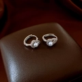 Detail van zilveren hartoorbellen met een parel en fonkelende strass steentjes - Oorklem Stijl (Flespompoen Hart) / Zilver