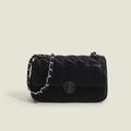 Primer plano detallado del elegante bolso acolchado negro con textura fina y cadena. - Negro