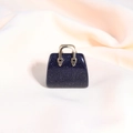 Macro shot of dark blue glitter stone handbag pendant on soft beige fabric texture - Blue Sandstone