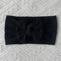 Close-up of black cable knit nylon baby headband with a decorative oversized soft bow - Black