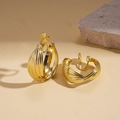Detail von gedrehten goldenen Metall-Clip-Ohrringen mit weichen runden Ohrpolstern - Ohrclip - Gold