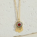 Dettaglio del ciondolo malocchio con motivo a occhio verde e ciondoli a cuore d'oro - Pendaglio a Cuore / Cuore Rosso