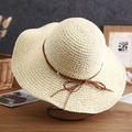 Detailed texture of woven straw sun hat featuring a delicate brown ribbon bow decoration - Hand-woven with Bow Tie / White