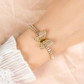 Detailed close-up of golden butterfly bracelet with green marquise stone and zircons - Olive Green