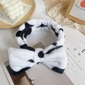 Cute cow print plush headband with large bow for face washing and makeup routines - Cow Print
